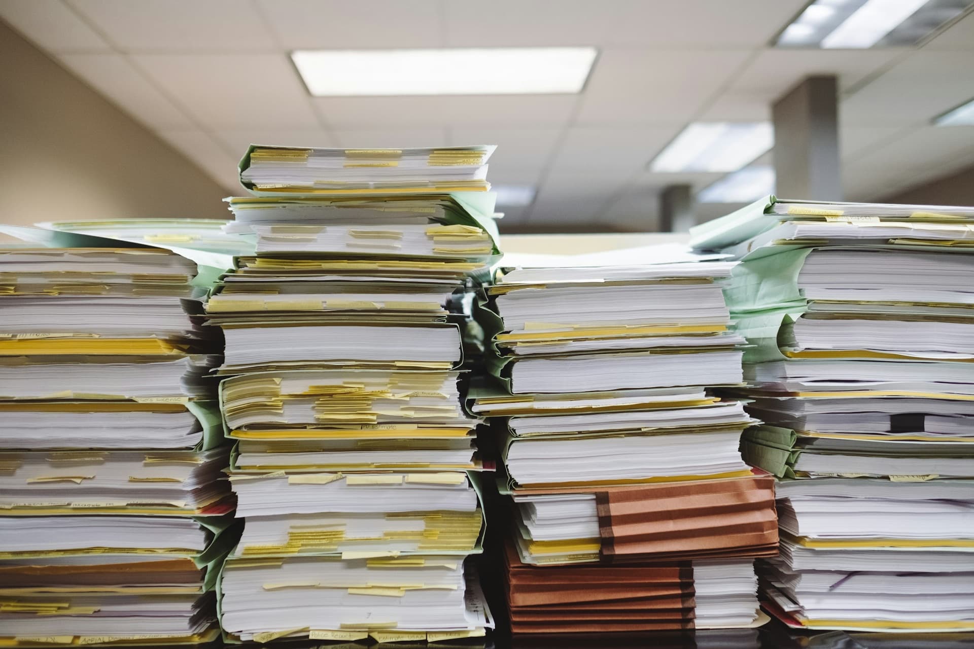 Des chemises et des classeurs de papiers empilés sur un bureau